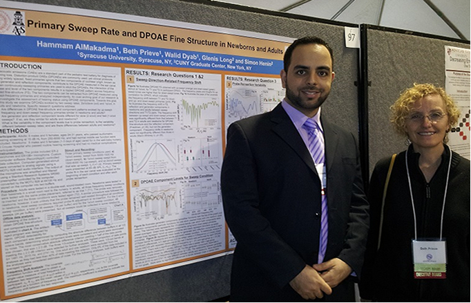 Two adults standing in front of a research poster.